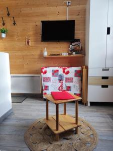 a living room with a chair with a red book on it at Le petit Nid Rouge in Ustou