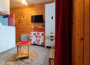 a kitchen with a table and a white refrigerator at Le petit Nid Rouge in Ustou
