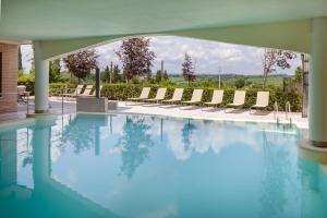 una piscina con sedie a sdraio in un edificio di Precise House Montaperti Siena a Siena