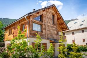 ein Holzhaus mit Bäumen davor in der Unterkunft Chalet Orezza in La Salle Les Alpes