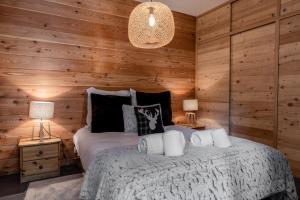 1 Schlafzimmer mit Holzwänden und 1 Bett mit 2 Lampen in der Unterkunft Chalet Orezza in La Salle Les Alpes