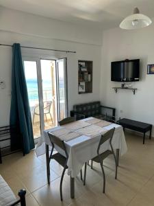 a dining room with a table and a view of the ocean at House With View in Paránimfoi