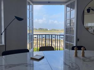 Villa Ster et Mer في Plobannalec-Lesconil: غرفة طعام مع طاولة ونافذة كبيرة