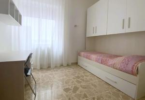 a small white room with a bed and a window at Le Rose Apartment in Ortona