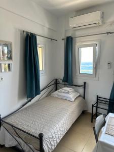 een slaapkamer met een bed met groene gordijnen en een raam bij House With View in Paránimfoi