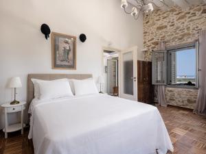 a bedroom with a large white bed and a window at Ondathaki Pirgos in Pírgos Psilonérou