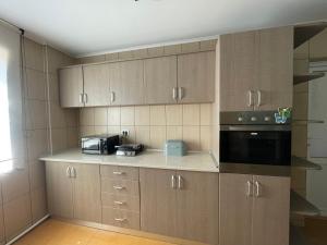a kitchen with wooden cabinets and a microwave at Casa Alleria in 2 Mai