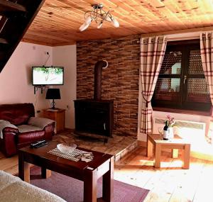 een woonkamer met een bakstenen muur en een open haard bij Mountain Soul Rest in Žabljak