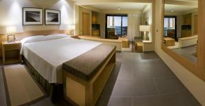 a bedroom with a large bed and a living room at Hotel Playa Calera in Valle Gran Rey