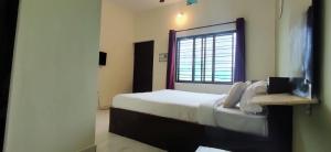 a bedroom with a large bed with a window at Lucky Inn Coorg in Kushālnagar