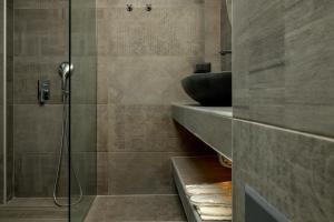 a bathroom with a shower and a sink at Olive Green Studios and Apartments in Plomarion
