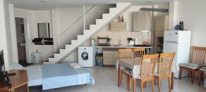 a kitchen with a dining table and a staircase at Marianna's apartment 2 in Nea Moudania