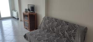 a bedroom with a bed and a tv on a dresser at Marianna's apartment 2 in Nea Moudania