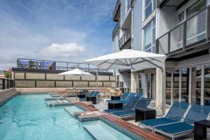 a pool with chairs and umbrellas next to a building at Shaw 1BR w Gym WD Rooftop nr U St bars WDC-560 in Washington