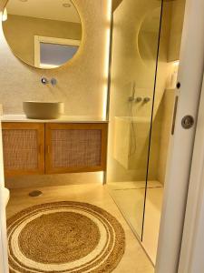 ein Bad mit einer Dusche, einem Waschbecken und einem Spiegel in der Unterkunft Soltroia lake Dream house in Troia
