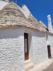 a white brick building with a wooden door at TRULLI MATRICE in Alberobello
