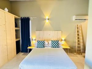 Un dormitorio con una cama con sábanas azules y una escalera en Azalo Country House, en Noto