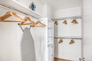 a closet with wooden hangers and a gray tie at Navy Yard 1BR w Gym WD steps from Nats Park WDC-325 in Washington, D.C.