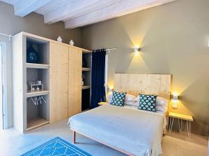 1 dormitorio con 1 cama con almohadas azules y blancas en Azalo Country House, en Noto