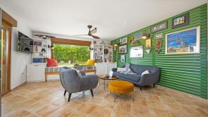 een woonkamer met groene gestreepte muren en stoelen bij Villa Tai in Puntera