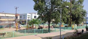 an empty park with a playground with a fence at Marianna's apartment 2 in Nea Moudania