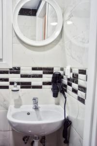 uma casa de banho com um lavatório e um espelho na parede em Dionysos Apartment in Central Athens em Atenas