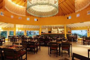 a restaurant with tables and chairs and a chandelier at Green Park en Punta del Este in Punta del Este