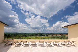 un gruppo di sedie seduti su un patio con cielo nuvoloso di Precise House Montaperti Siena a Siena