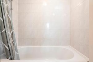 eine weiße Badewanne im Bad mit Dusche in der Unterkunft The Aristocrat - Fitzrovia - by Frankie Says in London