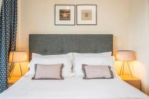 ein Schlafzimmer mit einem großen weißen Bett mit zwei Lampen in der Unterkunft The Aristocrat - Fitzrovia - by Frankie Says in London
