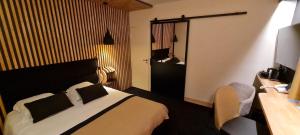 ラ・ロシェルにあるオテル レ ブリゼのベッド、デスク、椅子が備わるホテルルームです。