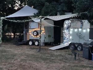 un rimorchio con luci e una tenda in un campo di Glamping in style, Prospector Tent a Crawley