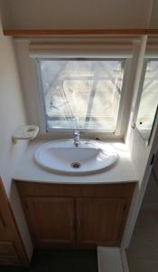 a bathroom with a sink and a window at Chriason Studios & Apartments in Skiros