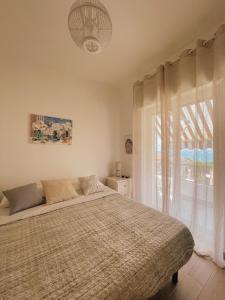 een slaapkamer met een bed en een groot raam bij Appartamento Corallo Rosso e Stella Blu in Belvedere Marittimo