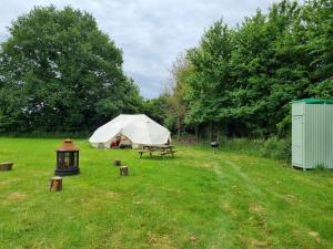 a tent and a picnic table in a field at Glamping in style, Prospector Tent in Crawley