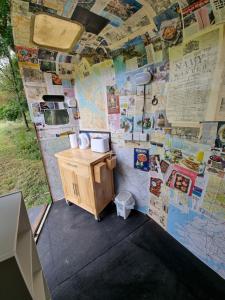 a small bathroom with a wall covered in posters at Glamping in style, Prospector Tent in Crawley