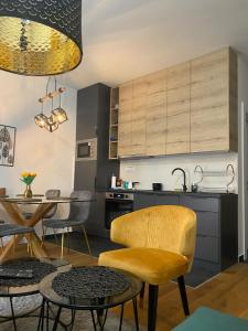 eine Küche mit einem gelben Stuhl und einem Tisch in der Unterkunft Fox Hill Apartman Zlatibor in Zlatibor
