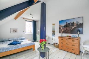 ein Schlafzimmer mit einem Bett und einem Tisch mit Blumen darauf in der Unterkunft Idyllic Farmhouse in Landsmeer