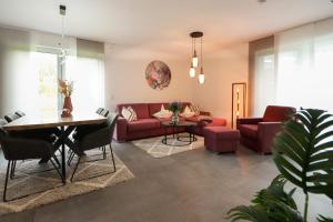 ein Wohnzimmer mit einem roten Sofa und einem Tisch in der Unterkunft Appartementhaus kleines Glück &MeineCardPLUS in Willingen