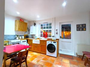 a kitchen with a washing machine and a table with chairs at Arts House centre of Harwich Harbour in Harwich