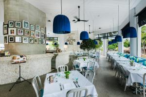 Hard Rock Hotel Pattaya في باتايا سنترال: غرفة طعام بها طاولات بيضاء واضاءة زرقاء