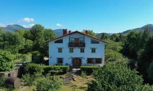 a white house in the middle of a forest at Agroturismo Kostegi in Urnieta