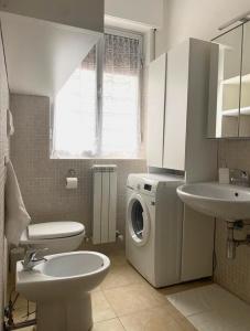 La salle de bains est pourvue d'un lave-linge et d'un lavabo. dans l'établissement Le Rose Apartment, à Ortona