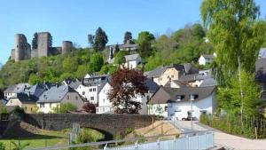Pension Burgklause في Schönecken: مجموعة من المنازل على تلة مع قلعة