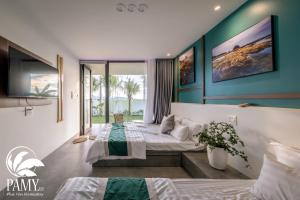 a bedroom with two beds and a large window at PAMY Homestay Phú Yên in Phu Yen