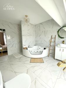a bathroom with a bath tub and a sink at Naturally Suite in Calais