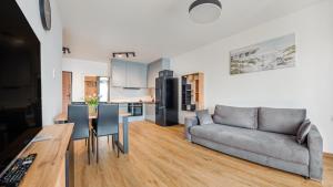 a living room with a couch and a table at Apartamenty Sun & Snow Baltea in Gdańsk