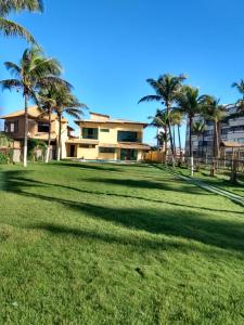 een grote tuin met palmbomen en een huis bij Beira Mar in Salvador