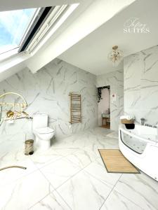 a white bathroom with a toilet and a sink at Naturally Suite in Calais