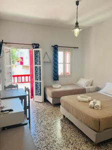 a bedroom with two beds and a desk and a window at Anna Studio in Katapola